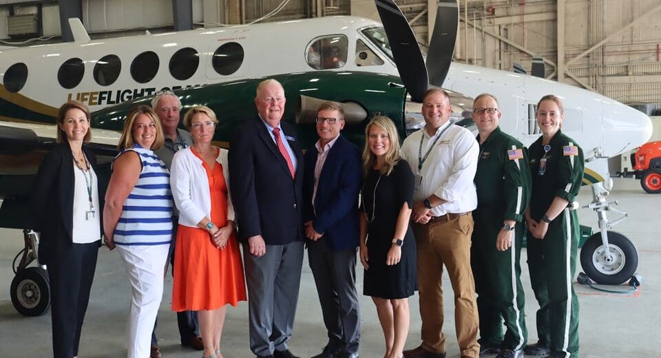 Representatives of Bangor Savings Bank and LifeFlight pose in front of a LifeFlight airplane