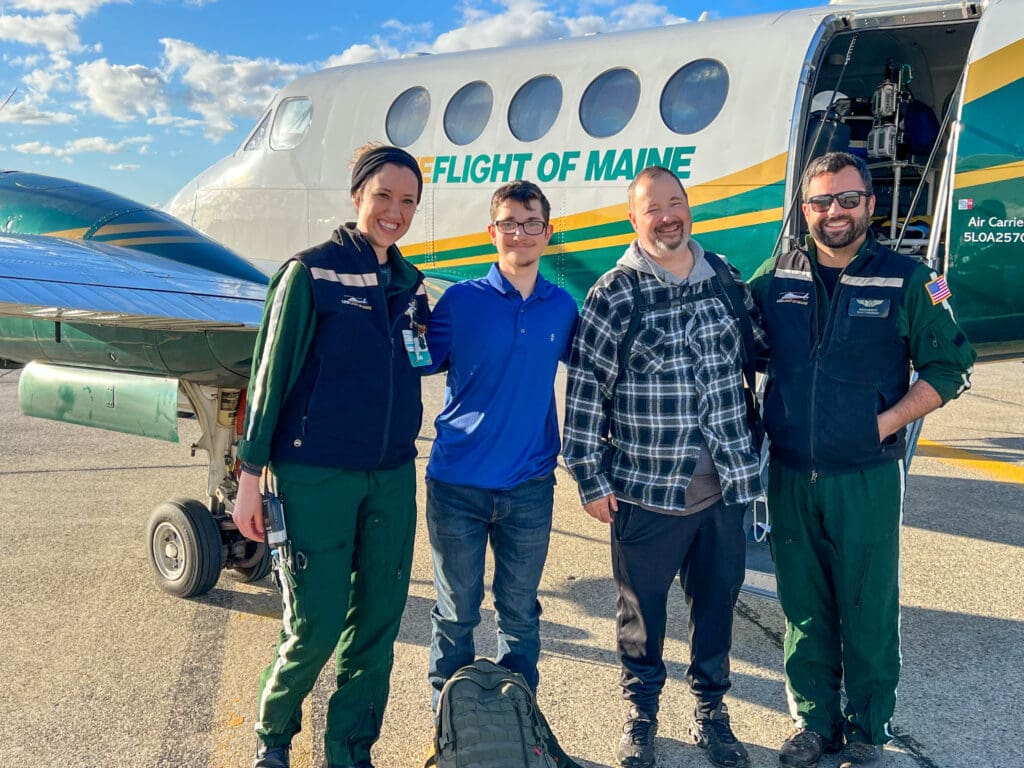 Four people standing in front of a LifeFlight helicopter.