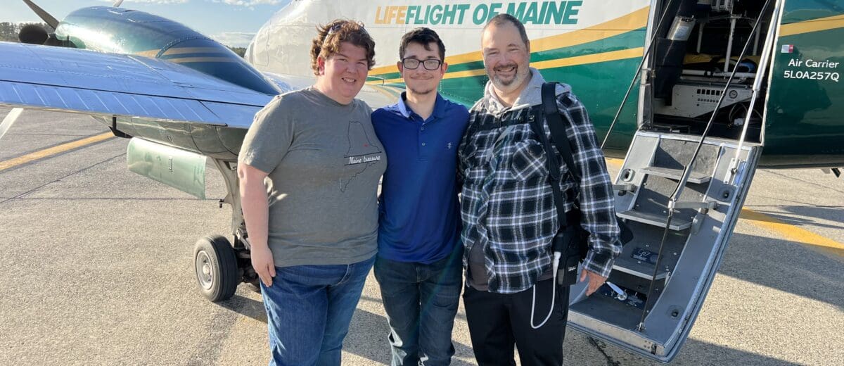 Eric Brasier poses with his wife and son in front of a LifeFlight airplane.