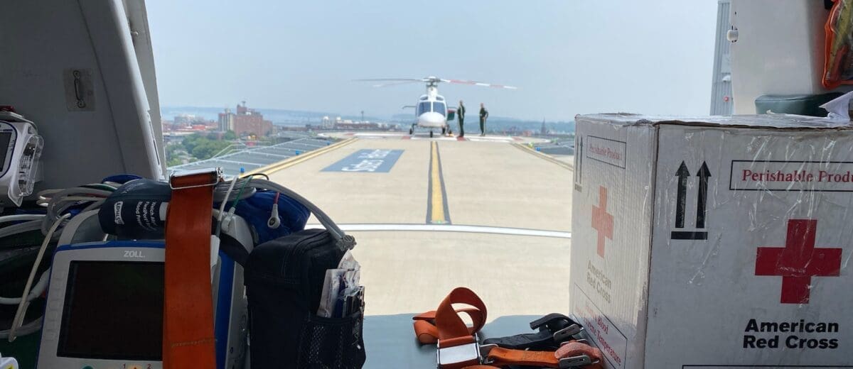 View of helicopter on hospital roof shot from the entry of a second helicopter.
