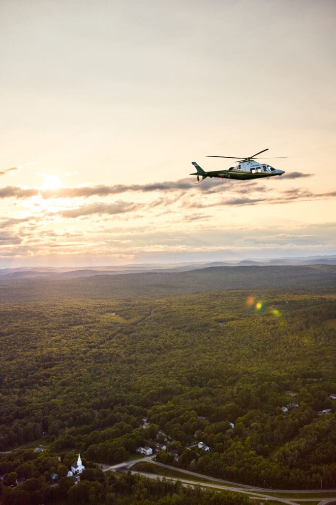 LifeFlight of Maine helicopter flying at sunset.