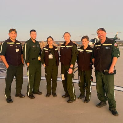 LifeFlight crew members stand on a helipad.