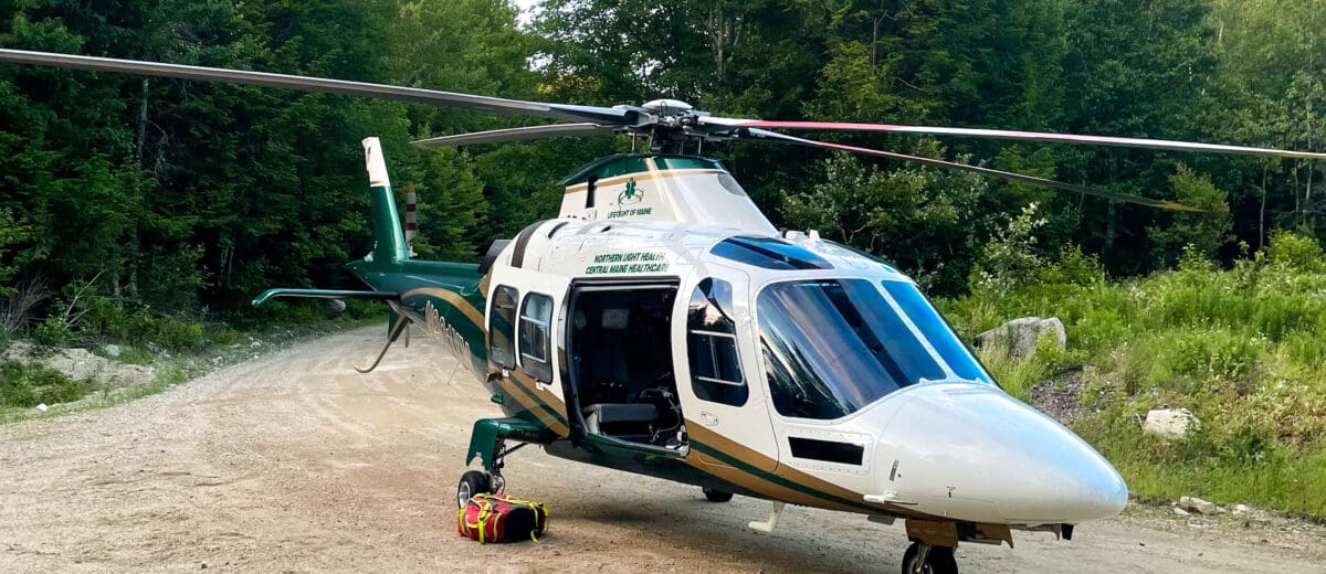 A LifeFlight helicopter on a dirt road.