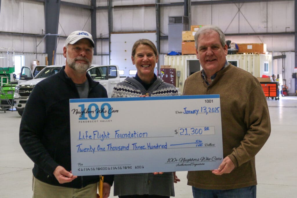 Members of the board of 100 Neighbors Who Care of Penobscot Valley visited LifeFlight’s Bangor hangar to drop off their donation. They are holding a check for $21,300.