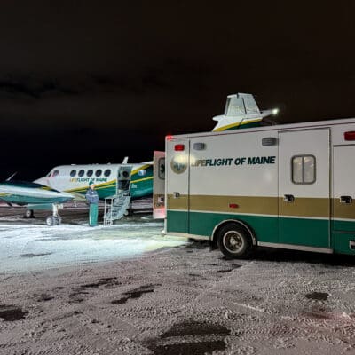 LifeFlight's airplane and ambulance on a snowy runway.
