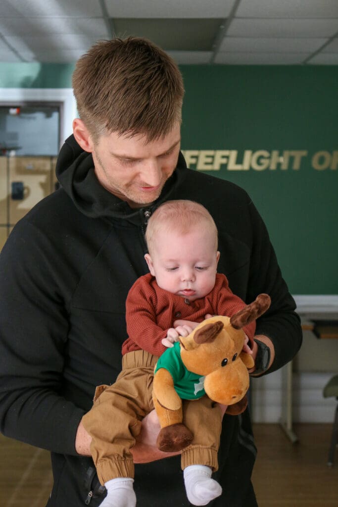 Flight paramedic Brad Alleger holds former patient Oliver White.