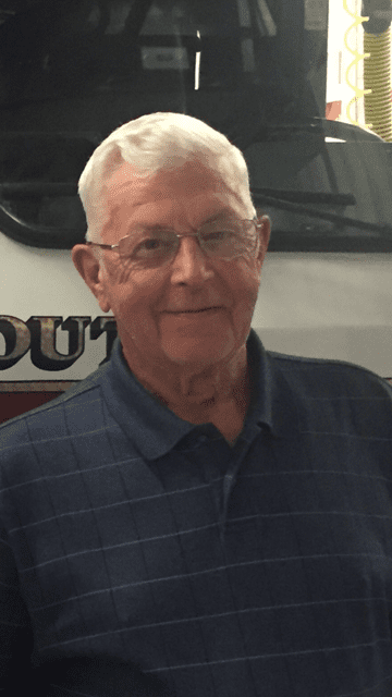 Nathan Randolph stands in front of a firetruck.