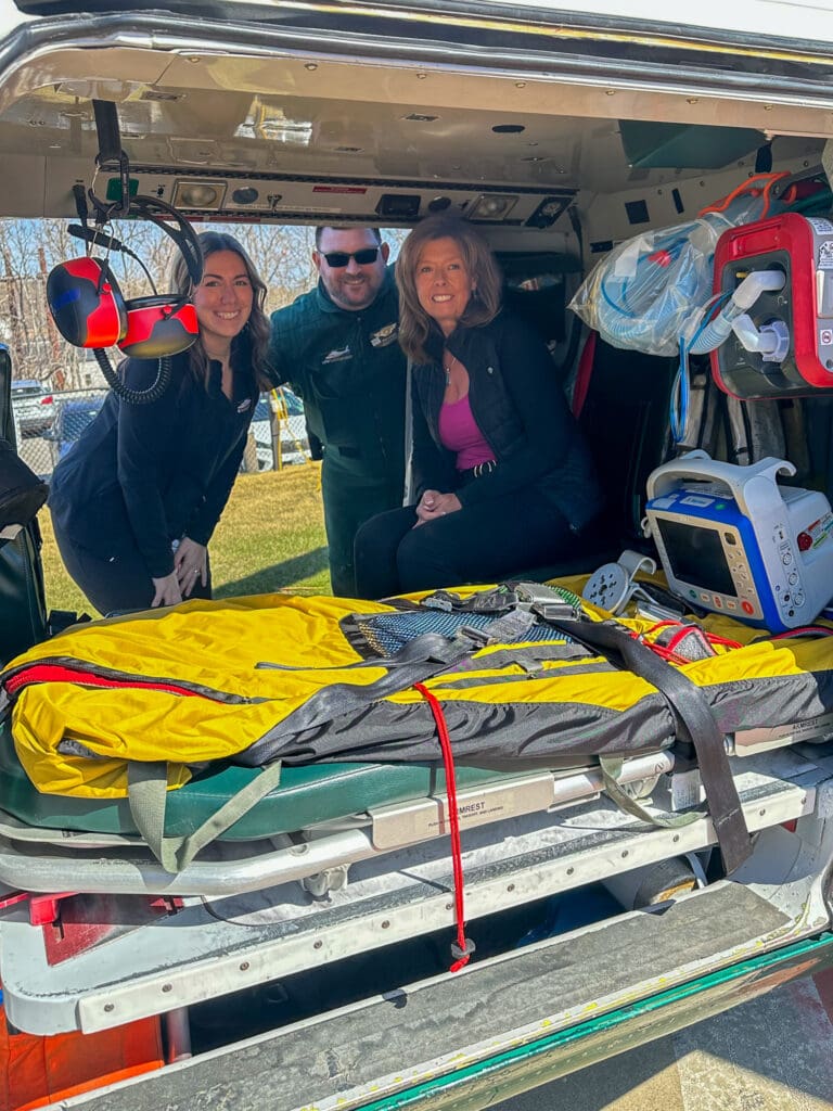 Flight nurse Casey Farrar, flight paramedic Mike Choate, and former patient Cheri Smith inside a LifeFlight helicopter.