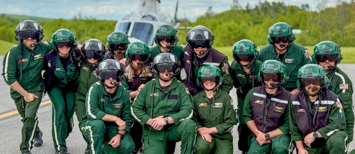LifeFlight of Maine crew members in their flight suits in front of a helicopter.