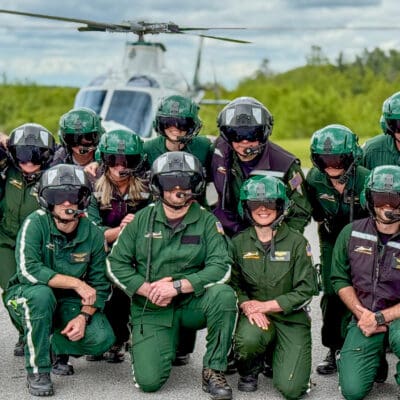 LifeFlight of Maine crew members in their flight suits in front of a helicopter.