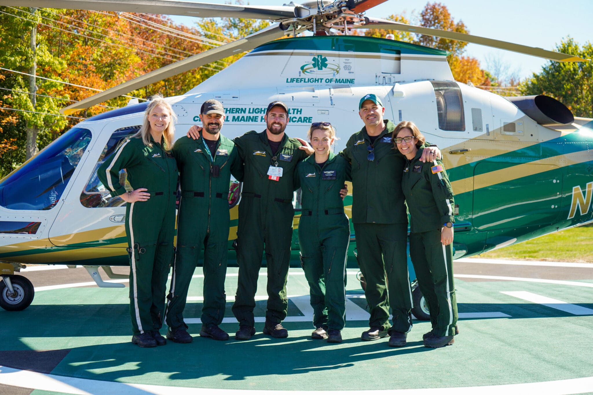 Flight crew members standing in front of a LifeFlight helicopter